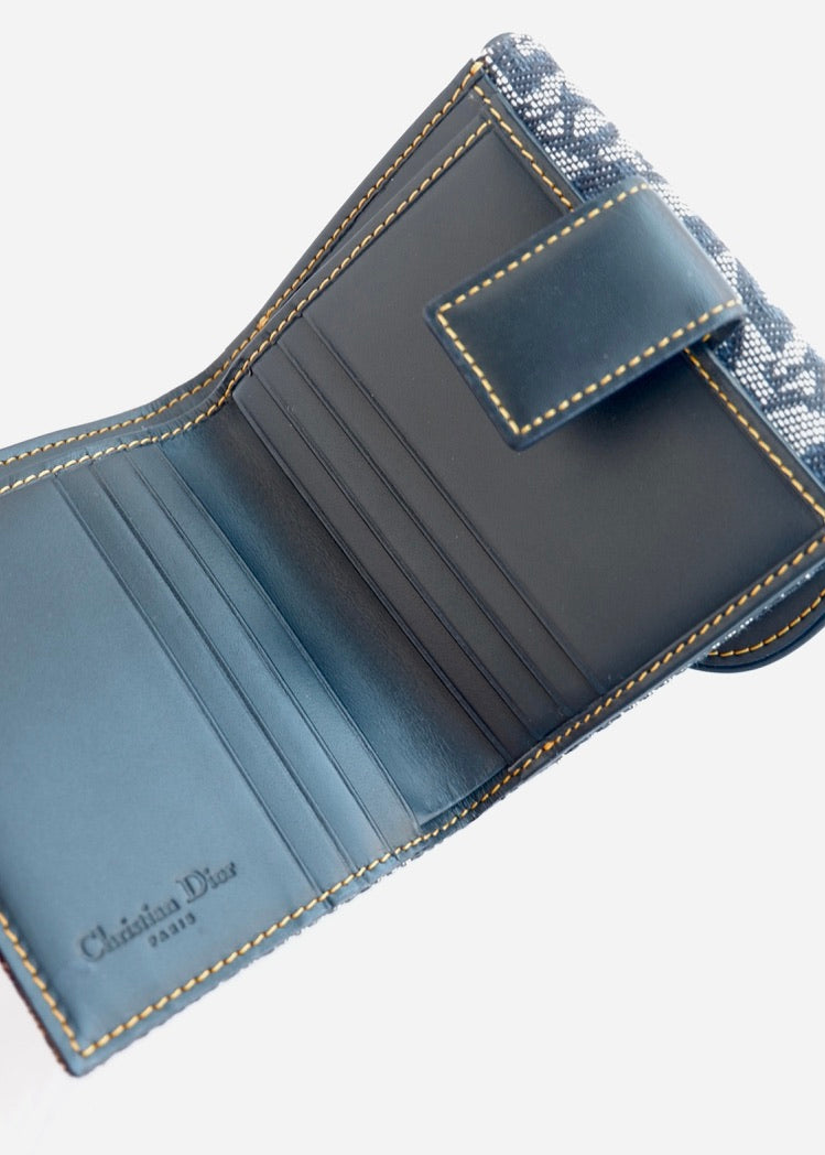 Portefeuille Dior authentique d'occasion, plié en deux, bleu marine, avec breloque D, motif Oblique.
