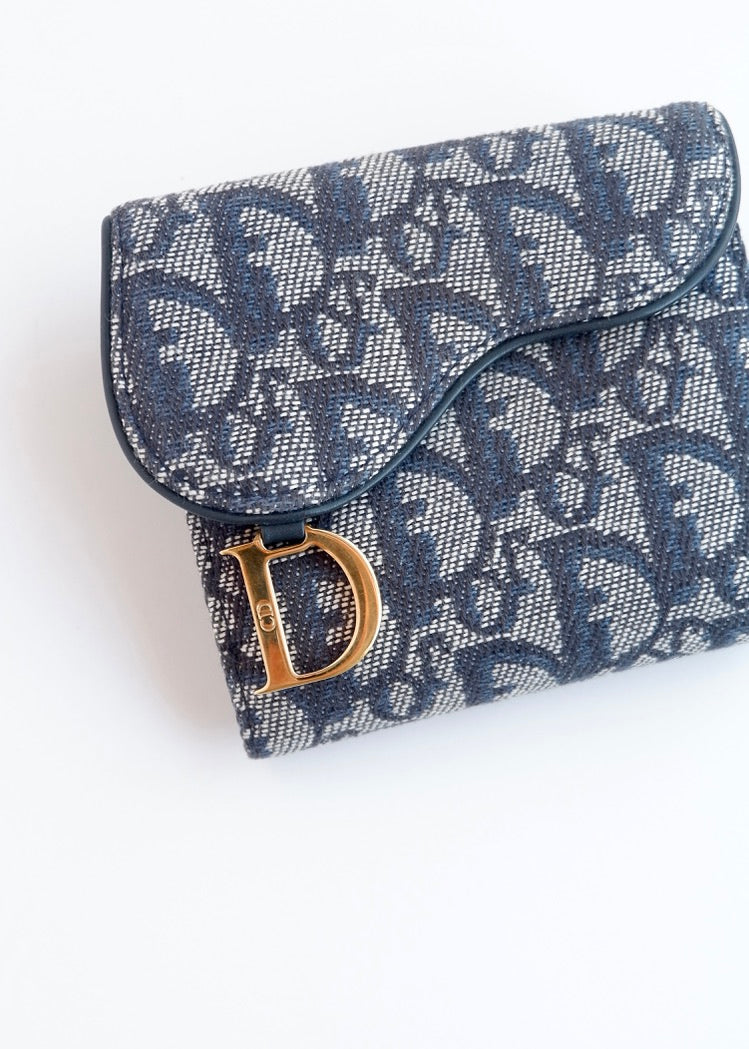 Portefeuille Dior authentique d'occasion, plié en deux, bleu marine, avec breloque D, motif Oblique.