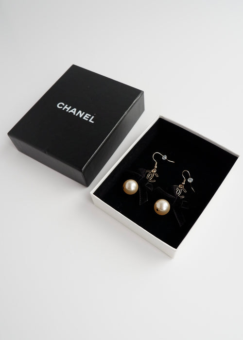 Authentiques Boucles d'Oreilles Pendantes en Perles Noires et Dorées CC Logo Nœud Chanel d'occasion