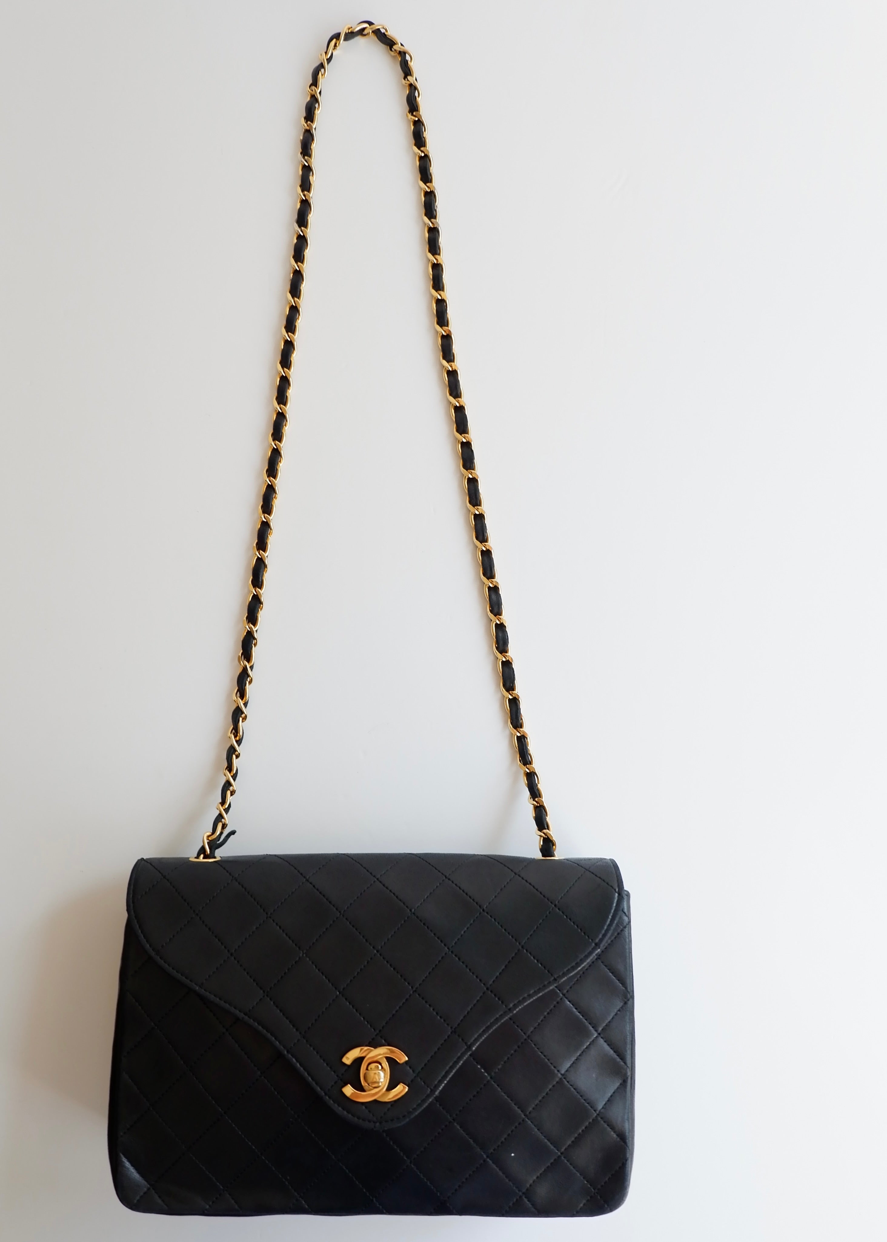 Authentique sac Chanel vintage d'occasion en agneau noir à rabat simple avec quincaillerie dorée