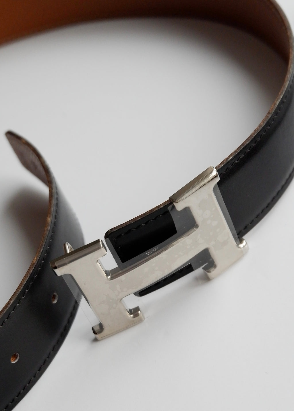 Authentique ceinture Hermes Constance H réversible en cuir noir/marron d'occasion SHW