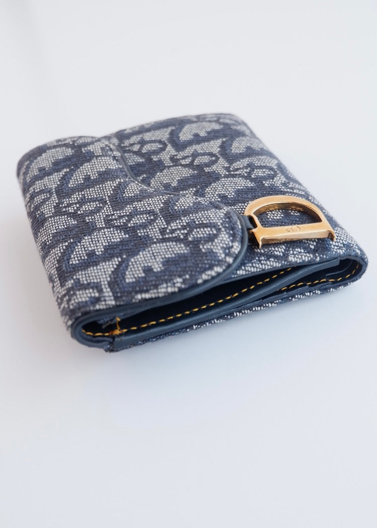 Portefeuille Dior authentique d'occasion, plié en deux, bleu marine, avec breloque D, motif Oblique.