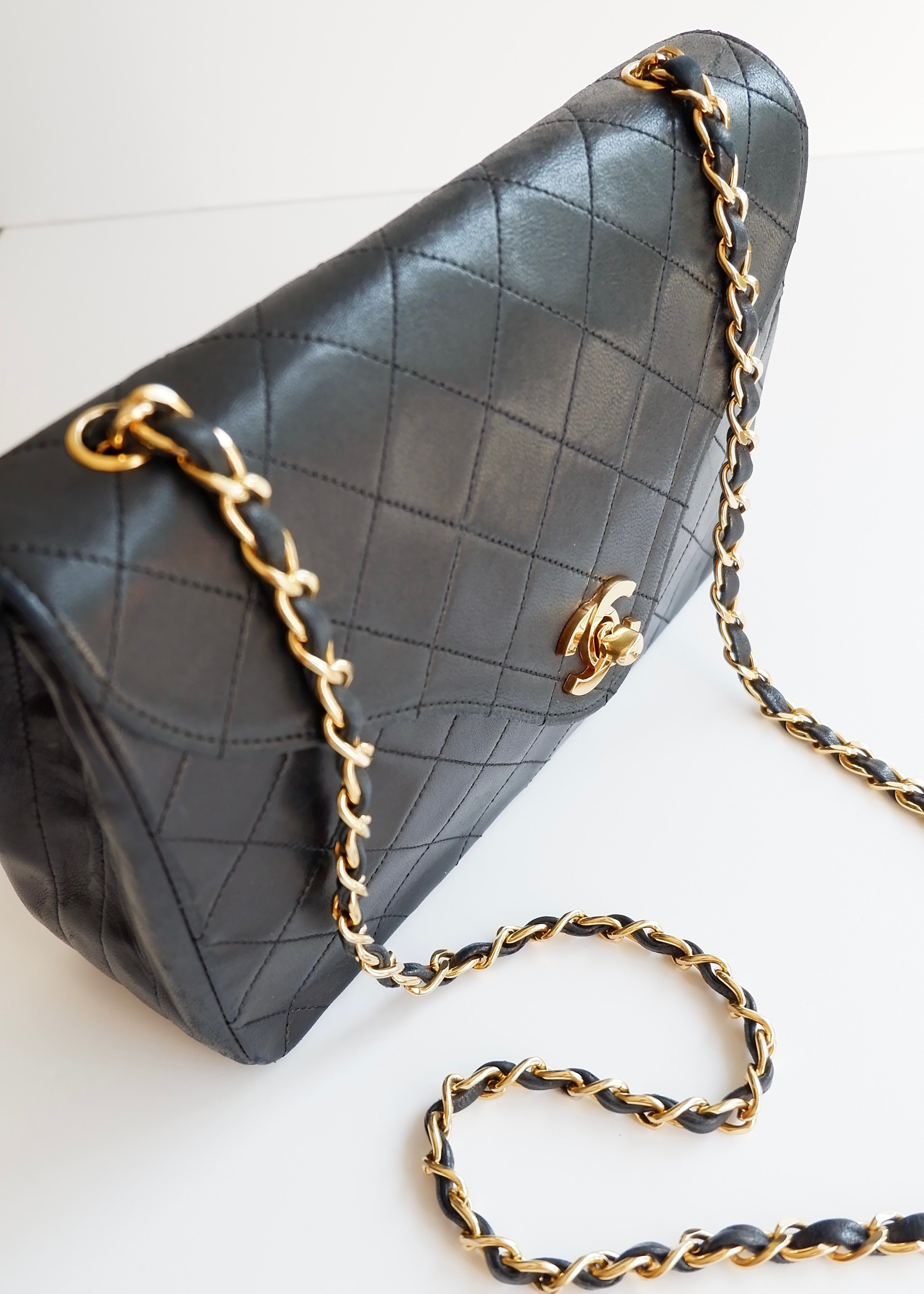Authentique sac Chanel vintage d'occasion en agneau noir à rabat simple avec quincaillerie dorée
