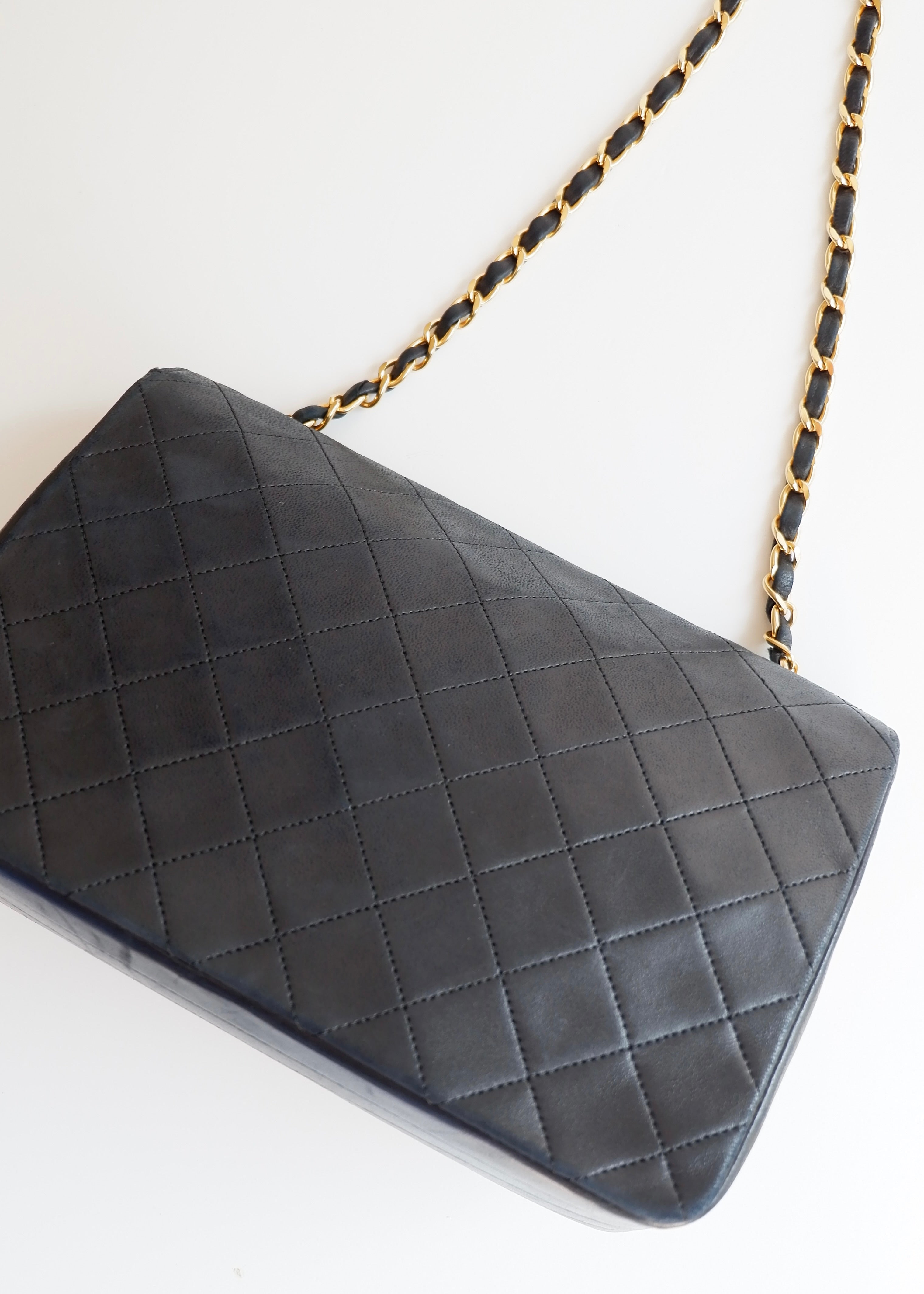 Authentique sac Chanel vintage d'occasion en agneau noir à rabat simple avec quincaillerie dorée
