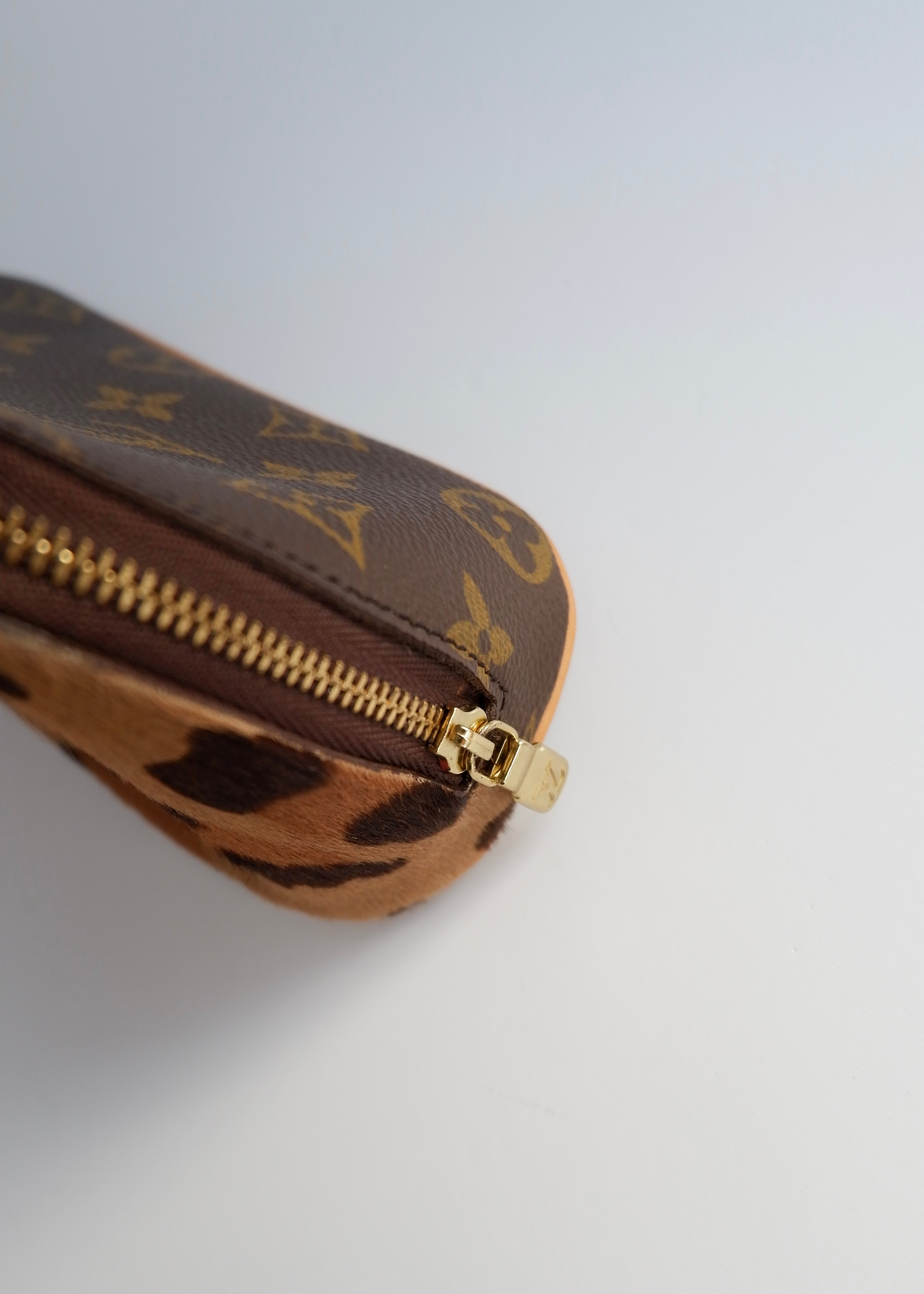 Trousse de toilette Louis Vuitton x ALAÏA authentique d'occasion, toile Monogram/crin de poney imprimé animal
