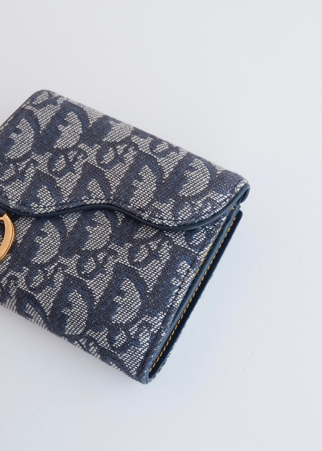 Portefeuille Dior authentique d'occasion, plié en deux, bleu marine, avec breloque D, motif Oblique.