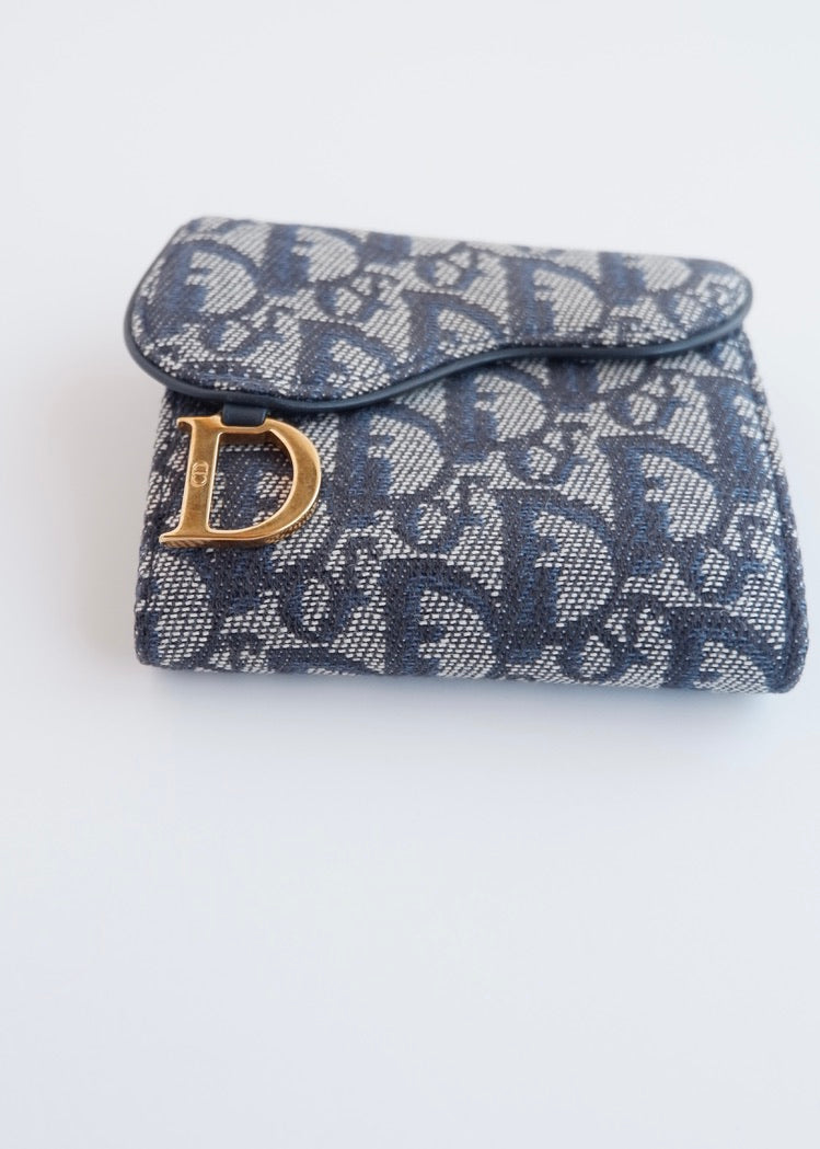 Portefeuille Dior authentique d'occasion, plié en deux, bleu marine, avec breloque D, motif Oblique.