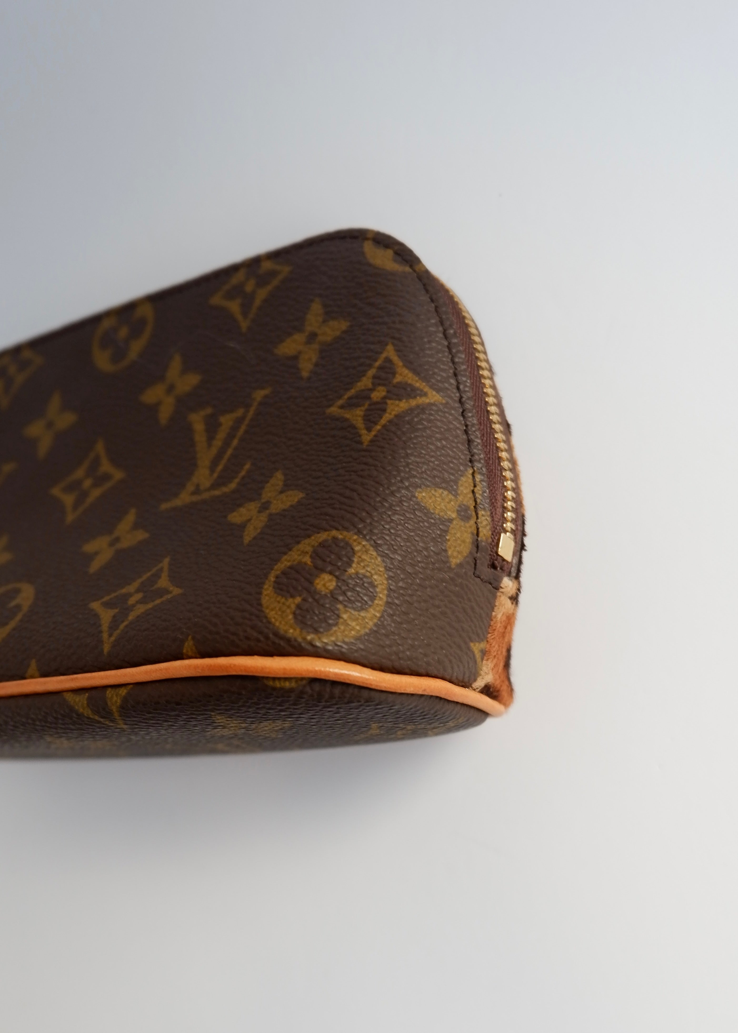 Trousse de toilette Louis Vuitton x ALAÏA authentique d'occasion, toile Monogram/crin de poney imprimé animal