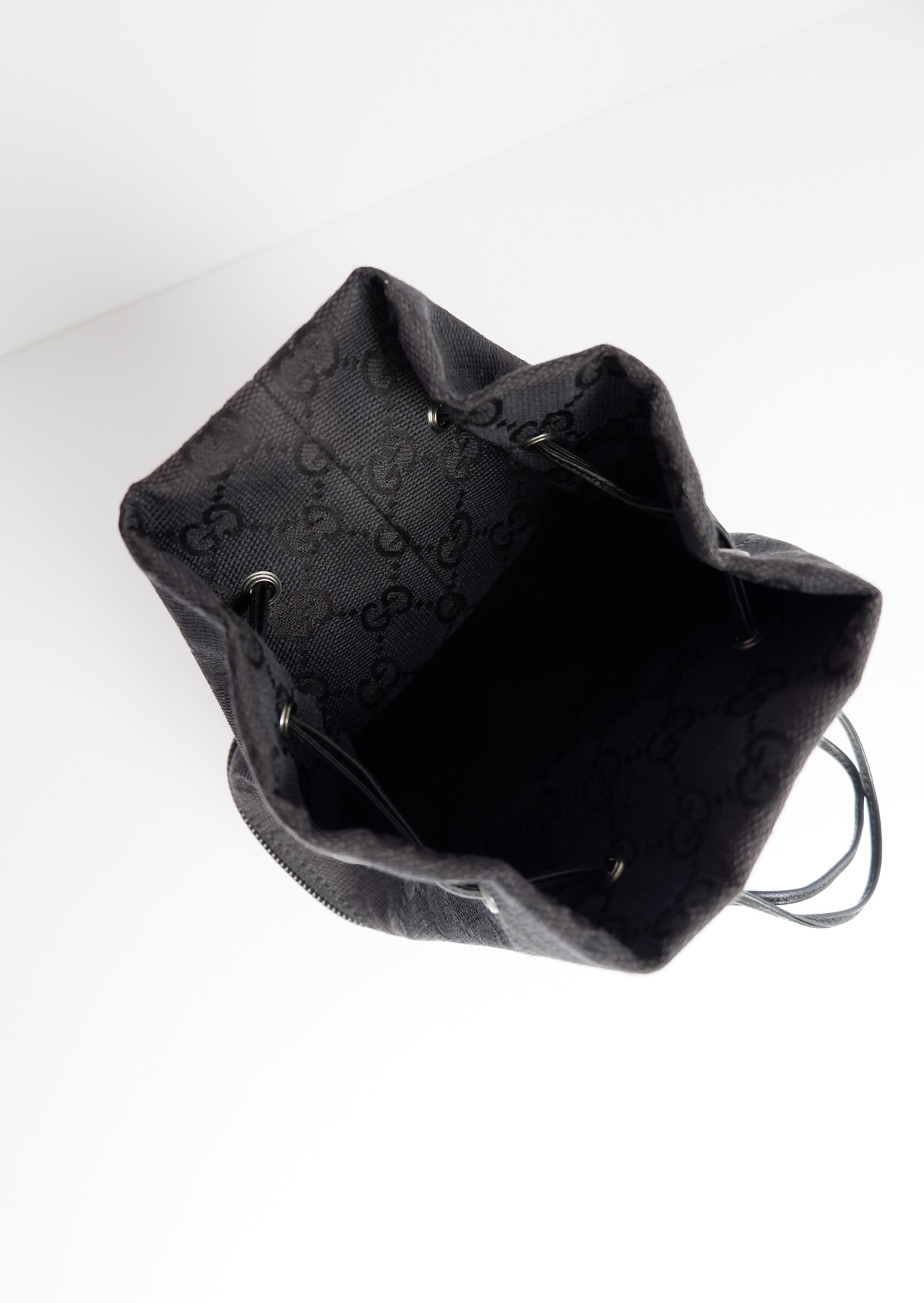 Pochette à cordon Gucci authentique d'occasion en toile GG noire