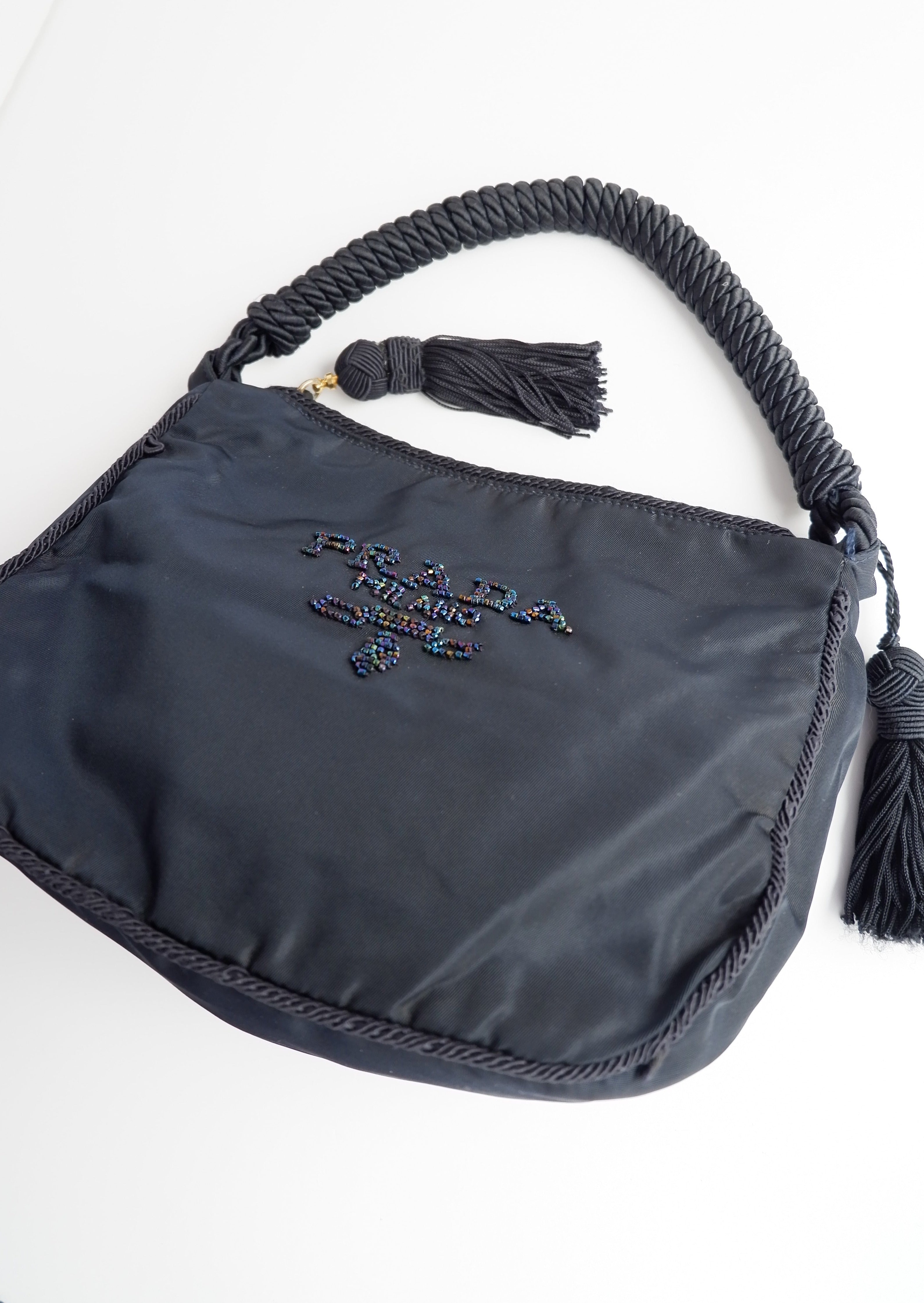 Sac à bandoulière Prada authentique d'occasion en nylon bleu marine avec logo perlé et pompon