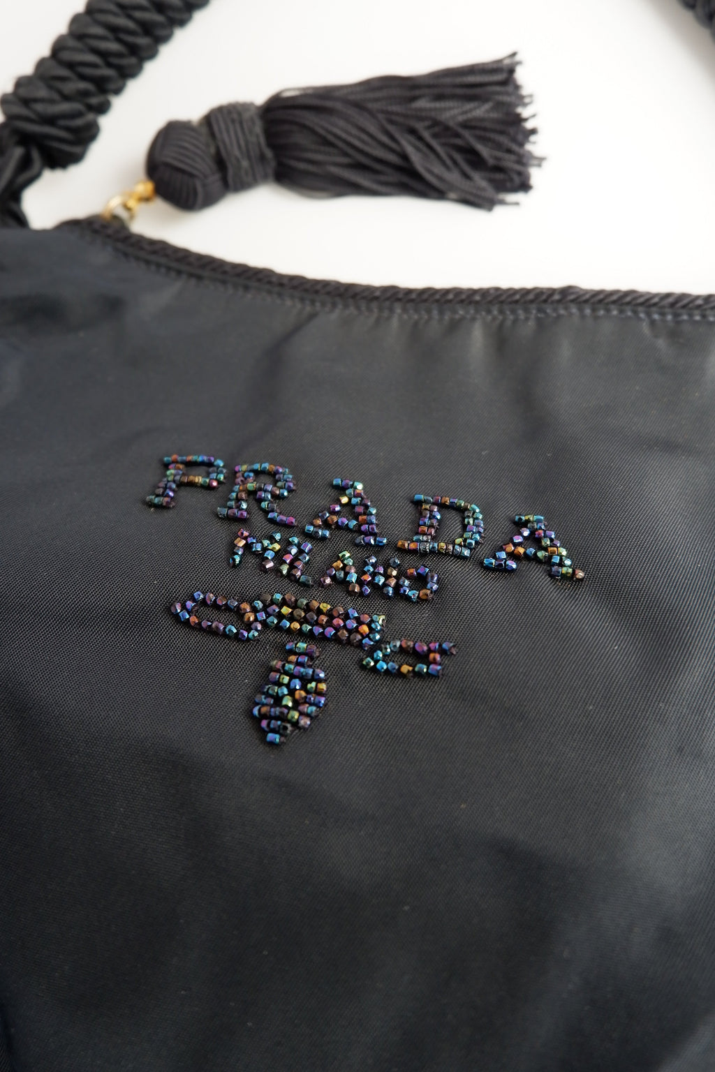 Sac à bandoulière Prada authentique d'occasion en nylon bleu marine avec logo perlé et pompon