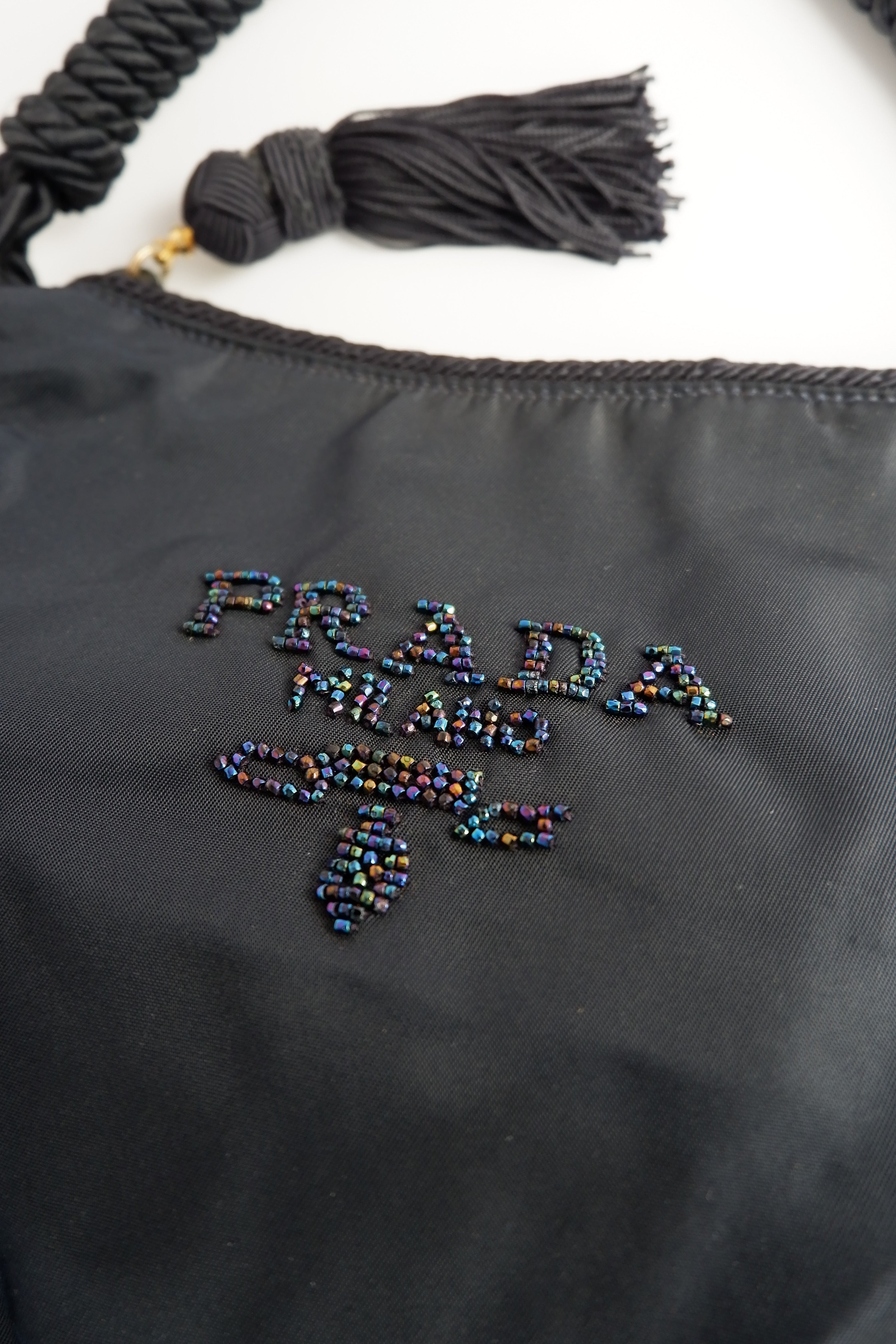 Sac à bandoulière Prada authentique d'occasion en nylon bleu marine avec logo perlé et pompon